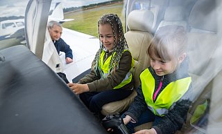 Uljana und Anastasia im Cockpit, Pilot Gerd Eichberg dahinter (v.l.) - er schenkt den Kindern ein besonderes Erlebnis. - Sarah Jonek Fotografie