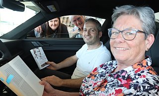 Brigitte Förster (vorne) liest normalerweise natürlich nicht am Steuer, demnächst aber im Autohaus Mahnerfeld. Inhaber Temel Bulut freut's. Anastasia Vollmer vom Autohaus (l.) und Regina Blomenkamp von "Löhne liest" auch. - Judith Gladow