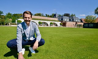 Klosterpforte Marienfeld: Der geschäftsführende Direktor der Klosterpforte, Christopher Schemmink, prüft schon mal den Rasenteppich der beiden Fußballplätze. Die UEFA hat vor einigen Wochen vor Ort die Rasenwurzeln gemessen und die Wässerung begutachtet. - Wolfgang Wotke