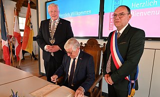 Eintrag ins goldene Buch der Stadt: Die Bürgermeister Daniel Hartmann (links) und Ludovic Gabrel (rechts) sowie Alain Babaut (Mitte). - Thomas Kube