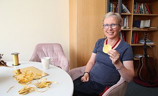 Dörte Vollmer sitzt in ihrem Büro im kirchlichen Zentrum von Neu-Eben-Ezer. Um den Hals trägt sie eine der Gold-Medaillen, die sie für eine Aktion gebastelt hat. - Nadine Uphoff