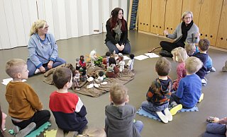 Die Scherfeder Kita-Kinder schauen mit ihren Erzieherinnen Silvia Nolte (v. l.) und Vanessa Bierwierth auf Gemeindereferentin Christina Bolte. Die sogenannten Egli-Figuren veranschaulichen die biblische Szene. Mittendrin die Handpuppe „Sharli“. - Dieter Scholz