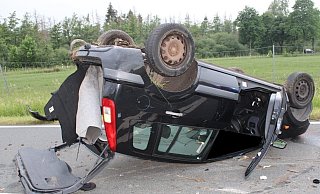 Das Auto liegt nach dem Unfall auf dem Dach und ist sichtlich beschädigt. - Polizei Minden-Lübbecke