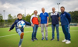 Frisches Grün statt staubiger Asche: Luis (9) aus der D-Jugend, Dirk Meyer, Jürgen Blume und die Trainer Torsten Esser und Luan Medzini (v.l.) vom TuS Hoberge-Uerentrup freuen sich, dass der Kunstrasentraum jetzt Wirklichkeit geworden ist. - Mike-Dennis Müller / www.mdm.photo