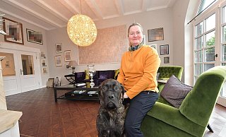 Marion Schlieckmann, hier mit dem Cane-Corso-Rüden Ewald, ist die Besitzerin des mondänen Anwesens in Avenwedde. Die Geschäftsfrau will ihren Lebensmittelpunkt nach Bielefeld verlagern und plant einen Verkauf des Landsitzes. Das Wohnzimmer im Haupthaus war früher einmal der Schankraum der Kneipe „Schlieckmann“. - Jens Dünhölter