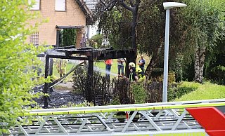 Der Brandort am Sonntag. Ein Feuerwehrmann steht vor den verkohlten Resten des Carports. - Charlotte Mahncke