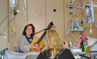 Marie-Pascale Gräbener (links) stimmt ein Lied auf der Gitarre an, Ute Grothues (rechts) gibt der musikalische Besuch Zuversicht in schweren Zeiten. - Andreas Zobe