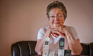 Ingrid Jürkenbeck mit ihrem vermeintlich kaputten Telefon (r.). Den silbern Apparat hatte die Rentnerin extra wegen der technischen Störung neu gekauft. - Foto: Andreas Zobe/NW