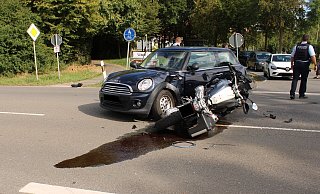 Der schwarze Mini und das BMW-Motorrad kamen nach der Kollision mitten im Kreuzungsbereich zum Stehen. - Polizei Minden-Lübbecke