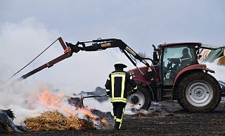 Mit Treckern wurde am Sonntagmittag begonnen, das Stroh auseinander zu ziehen. Foto: Thomas Kube - Thomas Kube