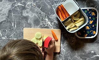 Eltern sollten ihre Kinder beim Zubereiten fürs Schulfrühstück der Pausenbox mit einbeziehen. Mit speziellen Kindermessern kann der Nachwuchs prima Gurken in Scheiben schneiden. - Katharina Eisele