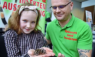 Die neunjährige Marie lässt sich von Claudio Vabuta eine Vogelspinne von beträchtlicher Größe auf die Hand setzen. - Barbara Franke