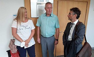 Trauern um ihren Sohn: Natalia und Viktor Fuhr auf dem Flur des Landgerichtes im Gespräch mit Anwalt Horst-Peter Strickrodt. - Ludger Osterkamp