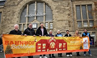 Ermöglichen den 10. Ökumenischen Gottesdienst „Bahnhof Bethlehem“ in der Bielefelder Bahnhofshalle am „Heiligen Abend“: Matthias Blomeier (Sozialpfarrer), Ulrich Paus (Caritas), Dennis Jablonski (Bahnhofs-Manager Bielefeld), Marlene van Randenborgh, Hedi Hesse, Ina Kreft (Sant’Egidio und Miteinander Stark e. V.), Susanne Luck (Diakonie Bielefeld) und Martin Zawieracz, (Diakonie für Bielefeld Bahnhofsmission). - Michaela Heinze