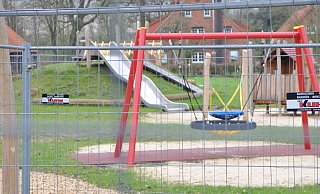 Mit Bauzäunen ist der neue Spielplatz in der Niehaussiedlung abgesperrt. Dahinter locken Vogelnestschaukel und Rutsche. - Frank Jasper