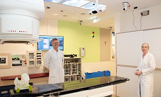 Chefarzt Attila Salay und die leitende Medizinisch-technische Radiologieassistenten Eveline Kröger begutachten die neue Stereovisionstechnologie am Linearbeschleuniger. Drei Kameras an der Zimmerdecke ersetzen die Markierungen auf der Haut des Patienten. - Brüderkrankenhaus St. Josef