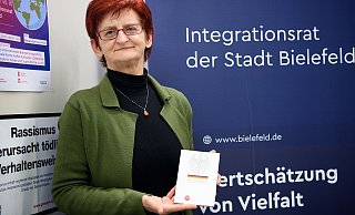 Murisa Adilović, Vorsitzende des Integrationsrat Bielefeld, hält das Grundgesetz in Händen. - Michaela Heinze