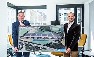 Stolz auf das gemeinsame Projekt: Bürgermeister Elmar Schröder (l.) und der Managing-Director von Scannell-Properties, Jordan Corynen, präsentieren eine Visualisierung der Pläne an der Autobahnauffahrt Diemelstadt. - Scannell Properties