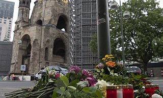 Blumen und Kerzen sind an einem Ampelmast auf der Tauentzienstraße in Berlin niedergelegt in Trauer um die getötete Lehrerin und zahlreiche Verletzte nach der Todesfahrt. - Paul Zinken