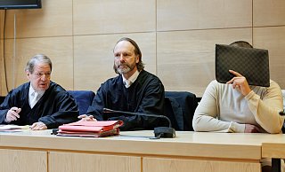 Lutz Klose (v.l.) und Mario Prigge, die Verteidiger des Angeklagten, sitzen neben ihrem Mandanten in einem Saal vom Landgericht. Der Prozess, in dem ein 41-Jähriger aus Bad Oeynhausen wegen Betruges an dem Fußball-Profi Marius Wolf angeklagt war, wurde eingestellt. - Friso Gentsch/dpa