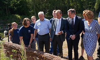 Auszubildende der Wasser- und Schifffahrtsverwaltung erklären der rheinland-pfälzischen Ministerpräsidentin Malu Dreyer (SPD, rechts) ein aus Weidengeflecht bestehendes Bauteil, das sie zur Renaturierung des Flusslaufs der Ahr nach der Flutkatastrophe eingesetzt haben. - Thomas Frey/dpa