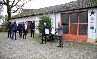 Der CDU-Landtagsabgeordnete Matthias Goeken (r.) und Marienmünsters Bürgermeister Josef Suermann (3. v. r.) mit den Zuwendungsbescheiden für das Dorfgemeinschaftshaus sowie das Feuerwehrgerätehaus in Großenbreden. - Madita Schellenberg