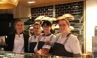 Löhner Bereichsleitung Marie Wittemeier (v. l.) und die "Verkaufsheldinnen" Natalja Simonova, Elke Stuke und Ann-Kathrin Stubenrauch stehen hinter dem Verkaufstresen im "Löhner Lieblingsplätzchen" in der Innenstadt. Seit Kurzem bietet Karlchen's Backstube als Sponsor von Arminia Bielefeld das Brot "Arminenkruste" an. - Anthea Moschner