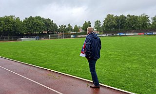 Der Vorstandsvorsitzende der SG FA Herringhausen-Eickum, Wolfgang Rullkötter, betrachtet den Rasen des Ludwig-Jahn-Stadions in Herford. Der Platz ist trotz anhaltender Regenfälle gut bespielbar. - Matthias Reiprich