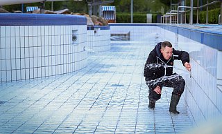 Das Wiesenbad wurde bereits mit frischem Wasser befüllt. Schwimmmeister Louis Schröter kontrolliert, ob dabei alles richtig funktioniert. - Sarah Jonek Fotografie