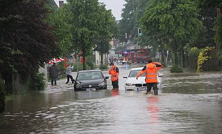 Feuerwehrleute helfen Autofahrern in Bünde, die nach dem Starkregen im Jahr 2021 auf der Engerstraße feststecken. - Florian Weyand