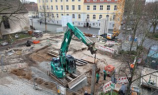 Bauarbeiter versenken Stahlträger in vorgebohrten Löchern. Der Verbau sichert die Baugrube vor umgebendem Erdreich. - Frank-Michael Kiel-Steinkamp