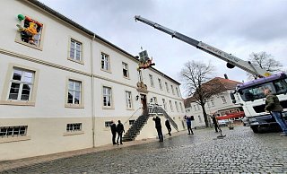 Mit schwerem Gerät werden die jecken Ehrenpräsidenten am Steinheimer Rathaus nach oben gehievt. - Madita Schellenberg