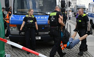 Berliner Polizeibeamte müssen einen Aktivisten der "Letzten Generation" wegtragen, der die Straße blockierte. - dpa