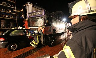 Großübung auf dem Gelände einer Autoverwertung Kerstingjohänner: Ein Auto ist unter dem Bus eingekeilt. Die Feuerwehrleute versuchen, den eingeklemmten Fahrer zu befreien.  - Sigurd Gringel