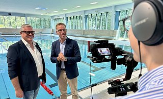 Sennebad-Initiator Franz-Josef Kaimann (l.) wird von Reiner Holznagel, dem Präsidenten des Bundes der Steuerzahler, am Beckenrand für eine TV-Show interviewt. - Jens Reddeker