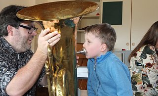 Am Tag der offenen Tür des Musikschulverbandes Espelkamp, Rahden, Stemwede konnten die Besucher alle Instrumente ausprobieren. Leiter Christian Wöbking hält die große Zugposaune für Josia, der kräftig hinein bläst. - Klaus Frensing