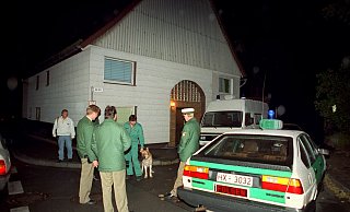 Polizisten und ein Einsatzfahrzeug stehen am 17. Oktober 1991 in Bredenborn im Kreis Höxter vor dem Haus, in dem Dietmar J. bis zur Tat lebte. - dpa/holger hollemann