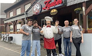 Renas Anit (v.l.), Fahrer Robin Schiefelbein, Ronijan Anit, Chef Cindo Anit und Bedienung Beste Sez vor dem "Zaubertopf" im Greffener Ortskern. - Markus Voss