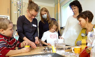 Ergotherapeutin Vera Gans (2.v.l.) und Musiktherapeutin Annette Gehler (r.) backen mit betroffenen Familien zu Weihnachten. - HandanHand