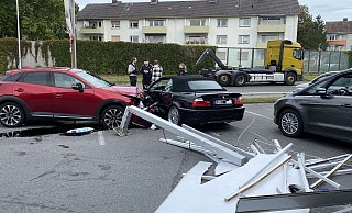 Die Trümmer des Werbeschildes liegen auf dem Boden. Zwei Fahrzeuge stehen sich schwer beschädigt gegenüber. - Jürgen Mahncke