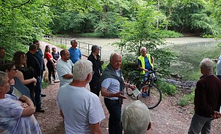 Manfred Burkamp (Mitte, weißes Hemd, Pullover) informierte beim „Dorfgespräch“ über die jahrelangen Bemühungen, den Hinnaksteich von Laub, Ästen, Schlamm und Müll zu befreien. - Knut Dinter