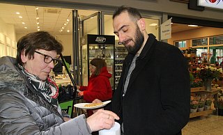 Ulrike Böttcher lässt einen Geldschein in der Sammeldose verschwinden und erhält zum Dank von Aiman Zeidan die erste frisch gebackene Waffel des Morgens. - Klaus Frensing
