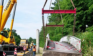 Am 25. Juni wurde die 110 Tonnen schwere Brücke von zwei Kränen neben der Fahrbahn der B1 abgelegt. - Ralph Meyer
