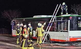 Einsatzkräfte des Löschzugs Buke löschen den brennenden Linienbus auf der Bundesstraße 64. - Feuerwehr Altenbeken