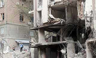 Ein Mann fotografiert einen Wohnblock, der durch den Einschlag einer russischen Rakete zerstört wurde. Laut Bundesinnenministerium ist eine zweistellige Zahl von rechtsextremen Deutschen in das Kriegsland gereist. - dpa
