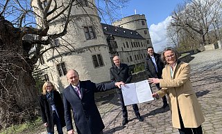 Fördermittel bringt Bauministerin Ina Scharrenbach (r.) mit zur Wewelsburg. Empfänger ist der Kreis mit Landrat Christoph Rüther (CDU, 2. v. l.). Museumschefin Kirsten John-Stucke (l.), Kreis-IT-MItarbeiter Peter Wibbe (2. v. r.) und CDU-Landtagsabgeordneter Bernhard Hoppe-Biermeyer freuen sich mit. - Jens Reddeker