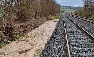 Neben dem Bahndamm haben die Regenfälle einen Bach entstehen lassen. - Deutsche Bahn