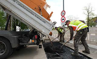 Arbeiter der Straßenbaufirma Denis Vahle schließen das Poller-Loch, das keines werden durfte. - Ulf Hanke