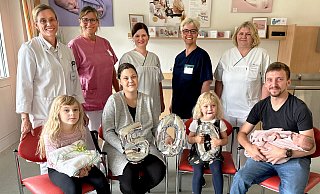 Friedlich schlummert die kleine Malea im Arm ihres Vaters André Hillemeyer, der sich mit seiner Frau Annika-Lorraine sowie den beiden Töchtern Neela (l.) und Aleyna ebenso über das Jubiläumsbaby freut wie (hinten v. l.) Birgit Kohlschein (leitende Oberärztin), Maria Roebers (Hebamme), Franziska März, Sandra Debruyne , Sandra Laker-Bunsen (Pflegeteam Geburtshilfe). - St.-Vincenz-Kliniken