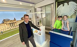 Am nachempfundenen Rednerpult des Deutschen Bundestags verschaffen sich die Geschwister Pauline und Lauritz Gehör. Die Angebote im Inneren des Lastwagens werden auch von Michael Hesse betreut. - Jens Reddeker